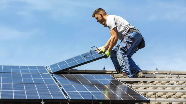 Homme en train d'installer des panneaux solaires